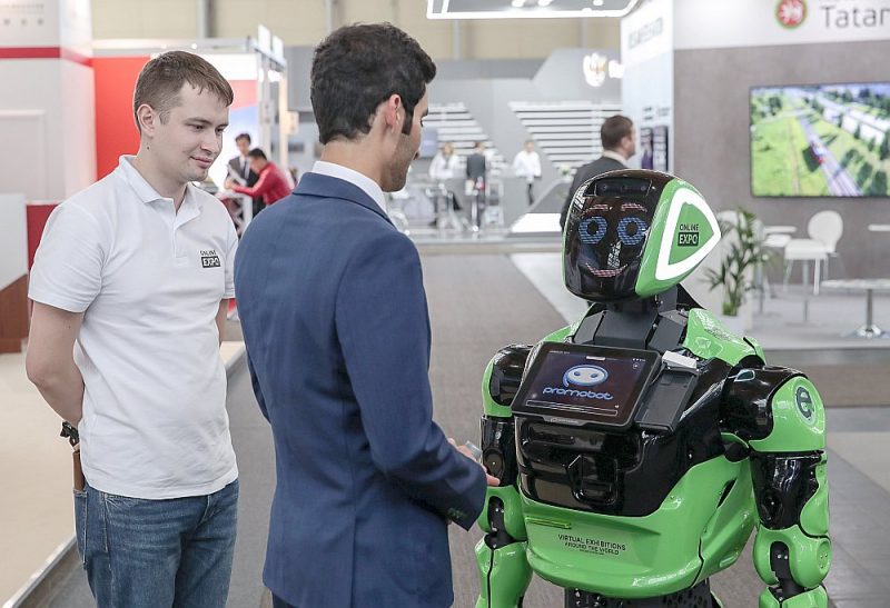 Apmeklētājs sasveicinās ar robotu Hannoveres gadatirgū, kas notika šomēnes.