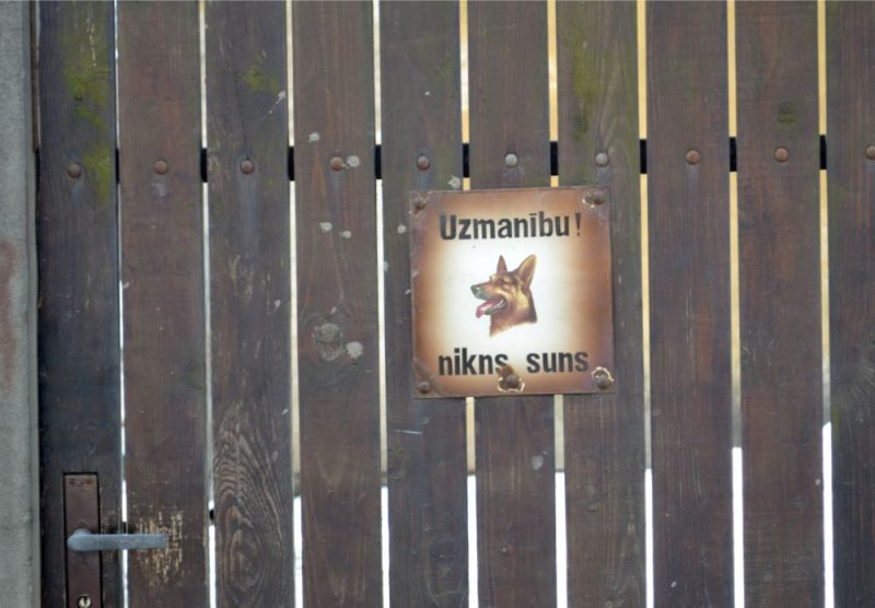 Brīdinājums “Nikns suns” uz sētas.