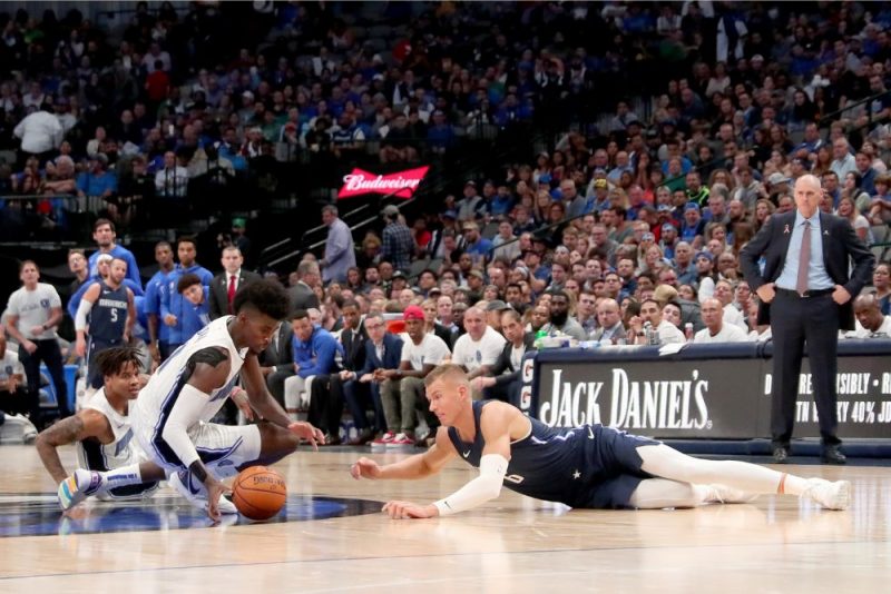 Kristaps Porziņģis (no labās) ar Džonatanu Aizeku cīnās par bumbu.