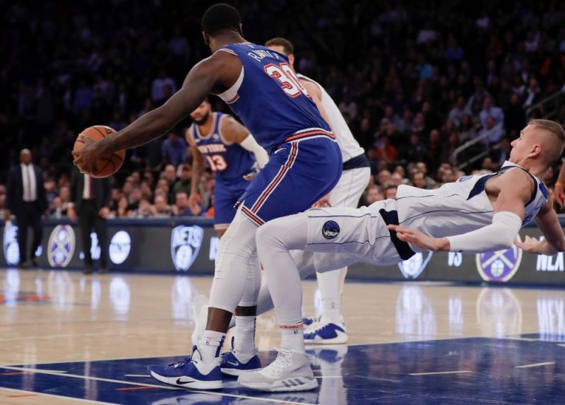 Kristaps Porziņģis (no labās) cenšoties apturēt “Knicks” spēlētāju Džūliusu Rendlu.