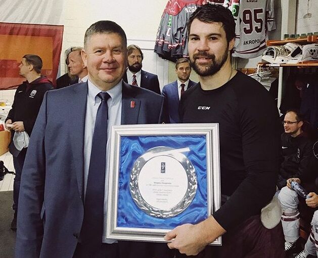 Kaspars Daugaviņš no LHF prezidenta Aigara Kalvīša saņem piemiņas velti par 100.spēli Latvijas izlases kreklā.