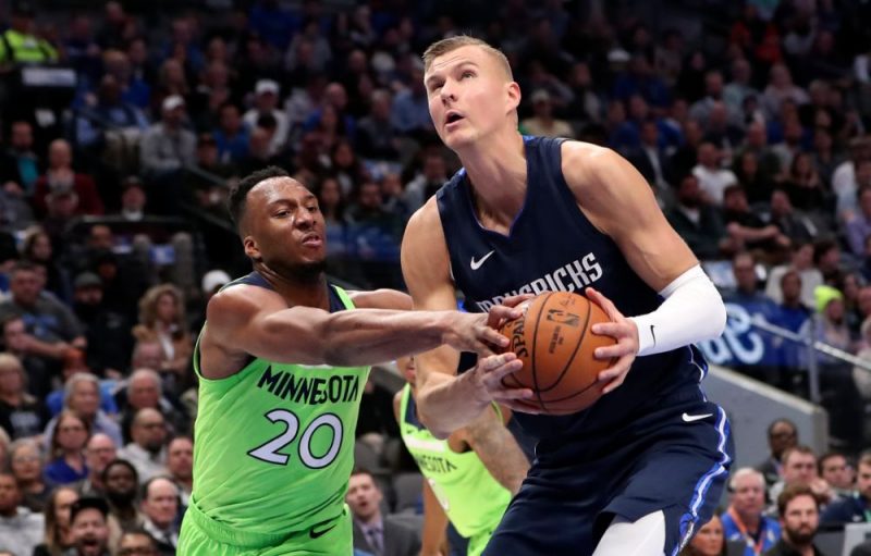 Kristaps Porziņģis (no labās) pret Minesotas vienības spēlētāju Džošu Okogi.
