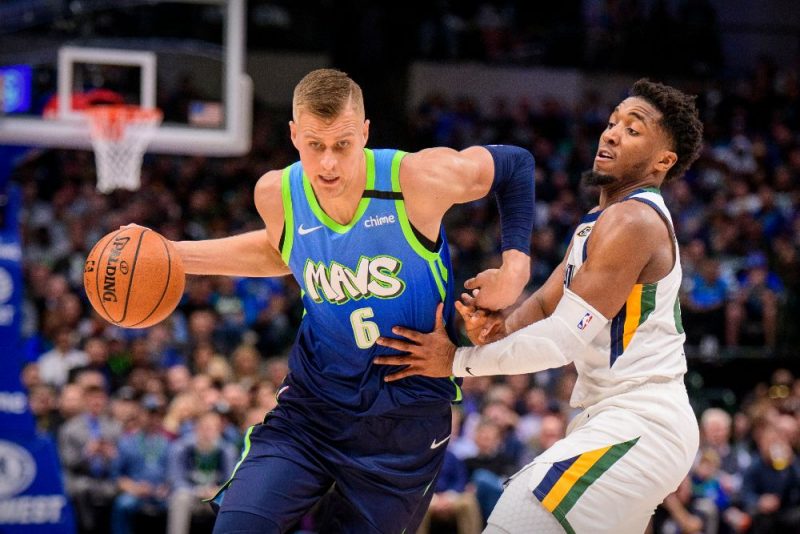 Kristaps Porziņģis no kreisās) cenšas apspēlēt Donovanu Mitčelu no Jūtas “Jazz” komandas.
