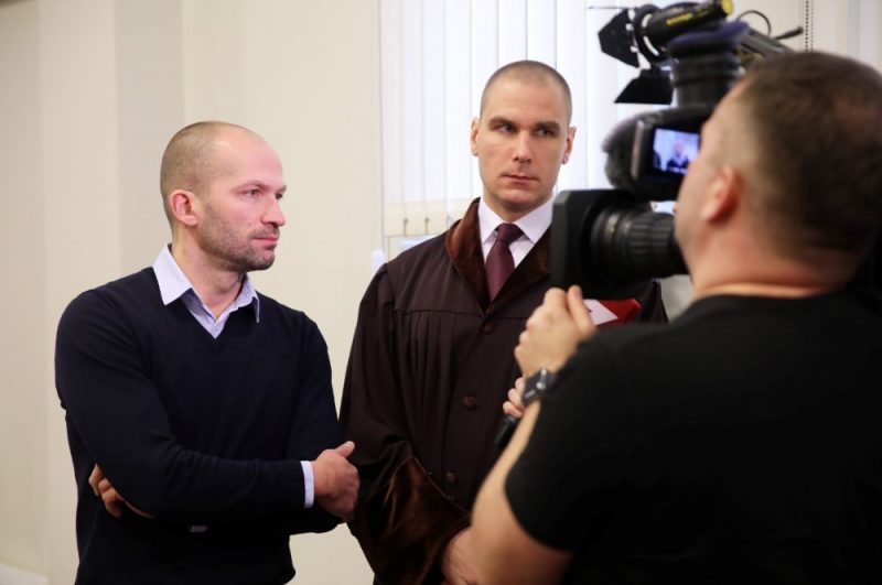 Apsūdzētais – arhitektu biroja “Kubs” valdes loceklis, arhitekts Andris Kalinka (no kreisās) atbild uz žurnālistu jautājumiem Rīgas pilsētas Pārdaugavas tiesas sēdes, kurā nolasa spriedumu Zolitūdes traģēdijas krimināllietā, pārtraukumā.