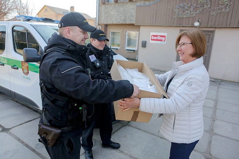 Jelgavas uzņēmuma “Berling” darbiniece nodod saražotās sejas maskas Jelgavas policijas pārstāvjiem.