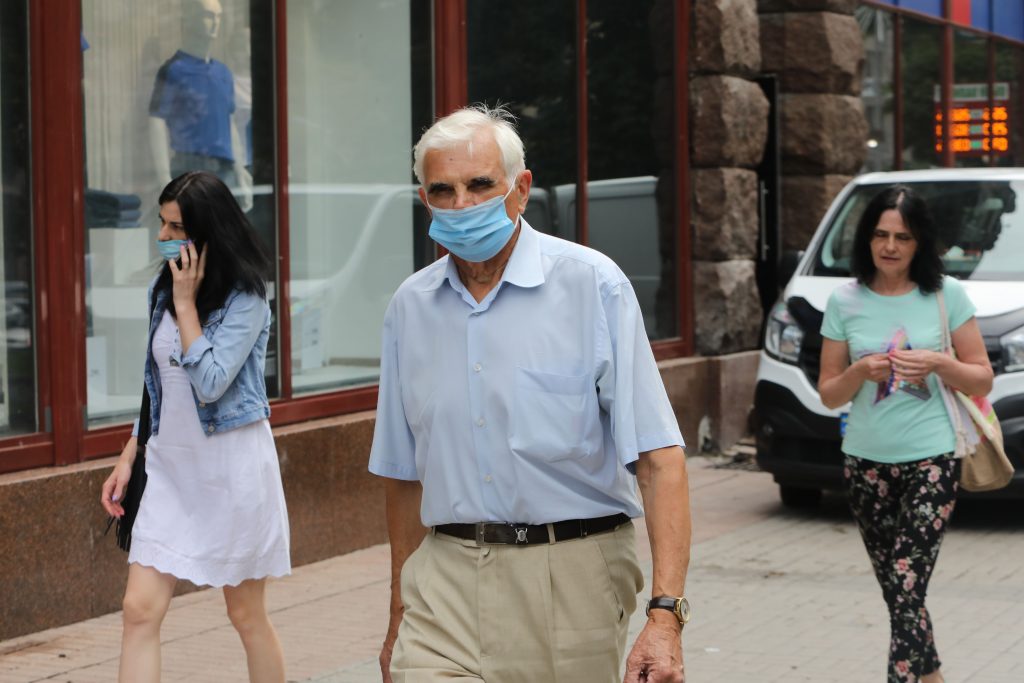 Vīrietis uz ielas ar sejas masku.
