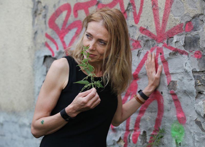 Ilze Burkovska-Jakobsena tepat Dzirnavu ielā pie apzīmēta brandmūra ar kupli sazaļojušām nātrēm, no kurām viņa nevairās – liekot gan Jāņu zāļu pušķī, gan savam dārzam brūvējot bagātīgu mēslojumu.